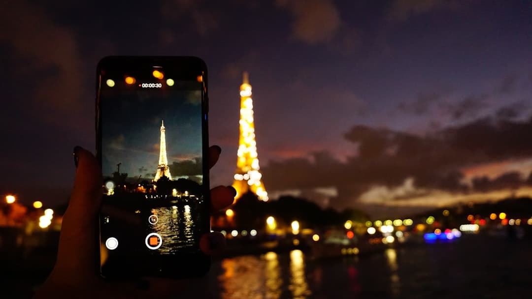 Smartphone filmant la Tour Eiffel illuminée à Paris la nuit