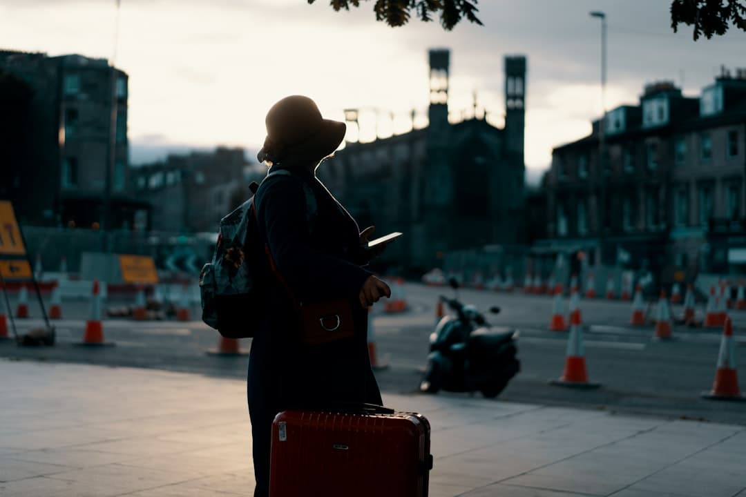 Voyageuse avec sa valise et son smartphone dans une rue, prête à partir de France avec une eSIM